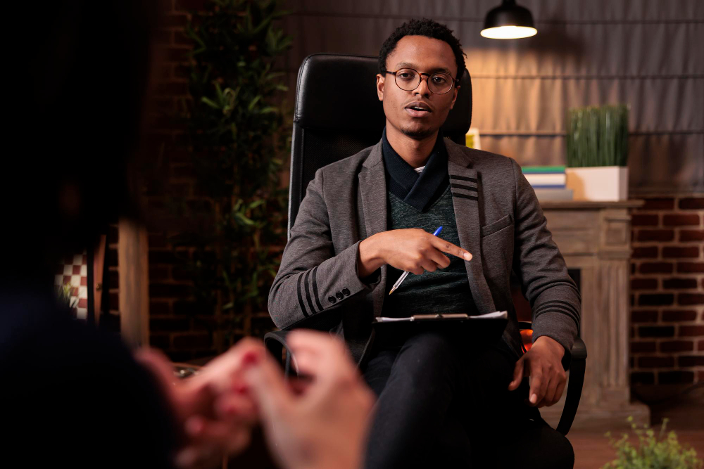 A therapist listening attentively in session, reflecting support for clients who’ve lived in survival mode and are now ready for growth through Bloom With Therapy.